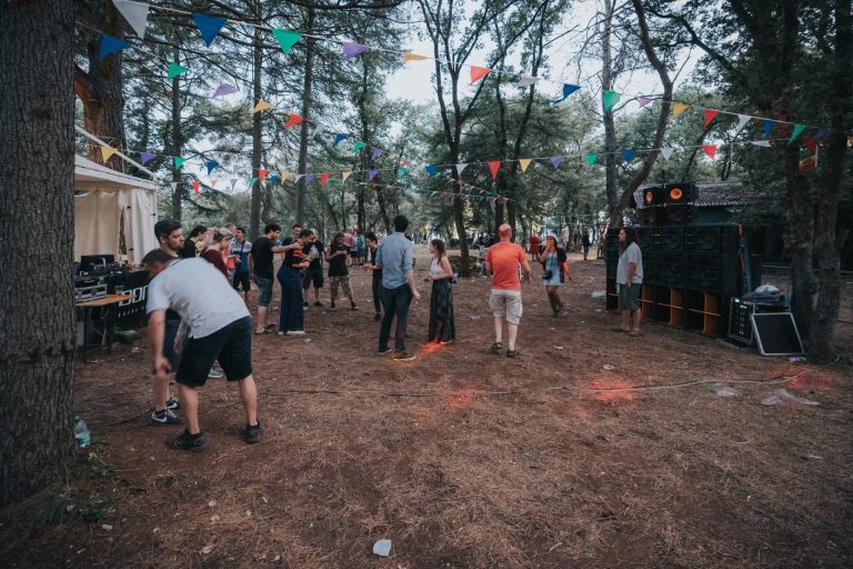 Posjetitelji festivala plešu ispred zvučnika u šumi.