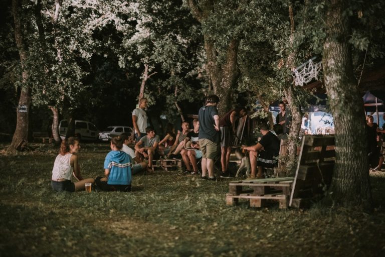 Posjetitelji festivala sjede na podu i paletama od drva i druže se